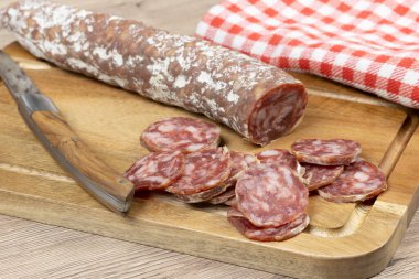 Dilimlenmiş kuru sosis, yakın plan, kesme tahtasının üzerinde.