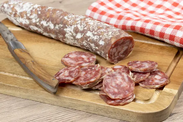 Dilimlenmiş kuru sosis, yakın plan, kesme tahtasının üzerinde.