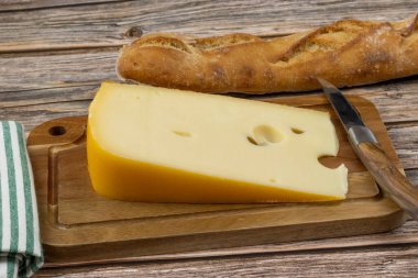 Peynir, bir dilim Maasdam, yakın plan, kesim tahtasında.