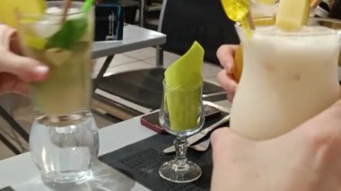 İnsanlar restoranda kokteyl içerek kadeh kaldırıyor.