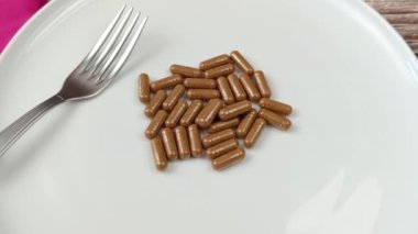 boş bir tabakta kapsül yığını, yakın plan.