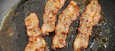 Pastırma dilimleri, tavada pişirme, yakın plan.