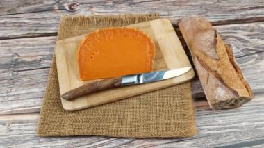 Bir dilim Fransız peyniri: ekstra eski mimolet, yakın plan, kesme tahtası üzerinde.