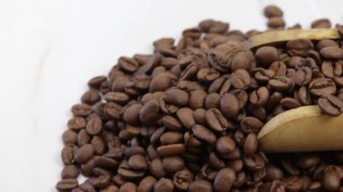 Kahve çekirdekleri ile dolu tahta kaşık, yakın plan.
