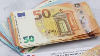 Fransız vergi kağıtları ve bir yığın avro banknotları. Yakın plan..