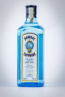 Bir şişe Bombay safiri marka Londralı kuru cin gri bir arka planda izole edilmiş.