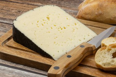 Bir dilim peynir: Pireneler 'den kara kedi, yakın plan, bir masanın üzerinde.