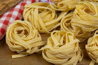 Kesme tahtasındaki çiğ tagliatelle makarnası