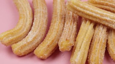 Birkaç churro, yakın plan, pembe arka plan.