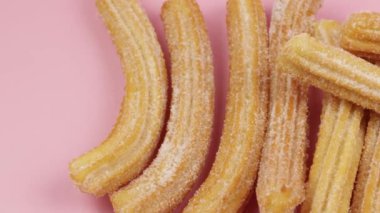 Birkaç churro, yakın plan, pembe arka plan.