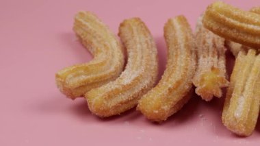Birkaç churro, yakın plan, pembe arka plan.
