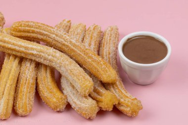 Birkaç churro, yakın plan, pembe arka plan.