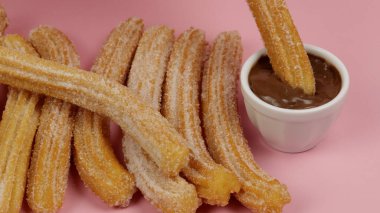 Birkaç churro, yakın plan, pembe arka plan.