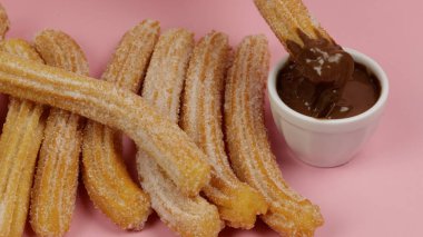 Birkaç churro, yakın plan, pembe arka plan.
