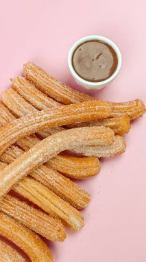 Birkaç churro, yakın plan, pembe arka plan.