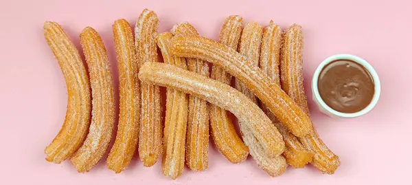 Birkaç churro, yakın plan, pembe arka plan.