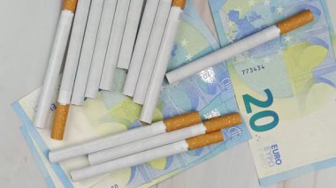 çok sayıda sigara ve 20 Euro 'luk banknotlar, yakın plan, üst görünüm.