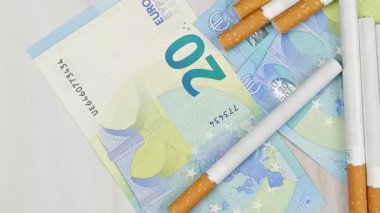 çok sayıda sigara ve 20 Euro 'luk banknotlar, yakın plan, üst görünüm.