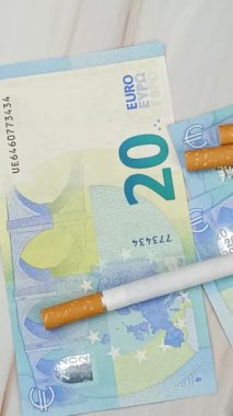 çok sayıda sigara ve 20 Euro 'luk banknotlar, yakın plan, üst görünüm.