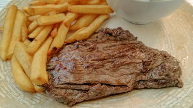 Biftek ve patates kızartması, yakın plan, tabakta.