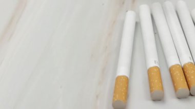 Bir kaç sigara, yakın plan, masanın üzerine yayılmış.