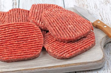 Kesme tahtasında çiğ hamburger bifteği.