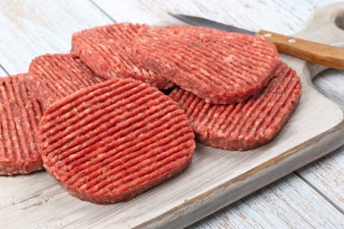Kesme tahtasında çiğ hamburger bifteği.