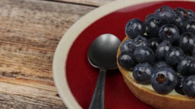 Yaban mersinli tart, yakın plan, ahşap bir masada izole edilmiş.