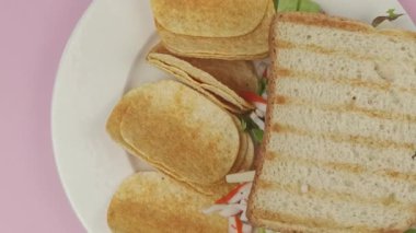 Surimi ve çiğ sebzeli sandviç, cips ve bir bardak kola, yakın plan.