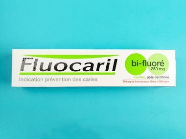 Mavi arka planda izole edilmiş iki florlu diş macunu kutusu.