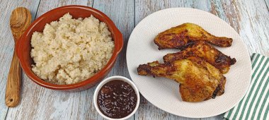 Bir tabak kızarmış tavuk budu ve kırık pilav, yakın plan.