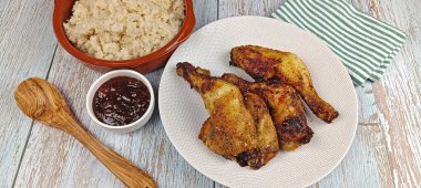 Bir tabak kızarmış tavuk budu ve kırık pilav, yakın plan.