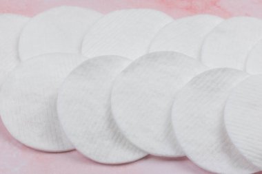 Pembe arka planda pamuk makyaj çıkarıcı pedleri