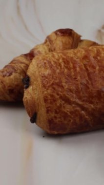 Kruvasan, çikolatalı acı ve masada kahve.