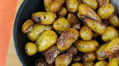 Kekik ve sarımsaklı yeni patatesleri dökme demir tavada kapayın.