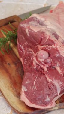 Çiğ kuzu bacağı, yakın plan, kesme tahtasında.