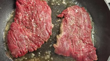 Tavada biftek pişiyor.