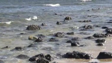 Deniz kenarındaki kayalar, dalgalar tarafından süpürüldü.