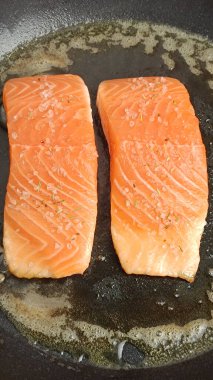 Tavada pişen somon parçaları.