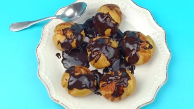 Bir tabak çikolatalı profiterol, yakın plan, üst görünüm.