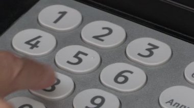 Bankamatiğe banka kartı kodunu yazan bir kadının elini kapat.