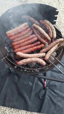 Sosisler ve merguez mangal ızgarasında pişiyor.