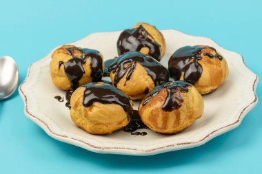 Bir tabak çikolatalı profiterol, yakın plan.