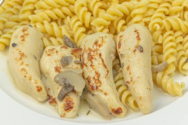 Mantar soslu tavuk filetosu ve makarna, yakın plan, tabakta.