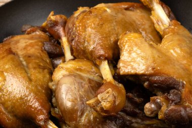 Ördek bacakları kaynıyor, tavada yemek pişiriyor.