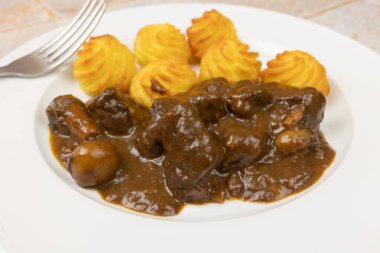 beef bourguignon and duchesse potatoes, close-up, on a plate clipart