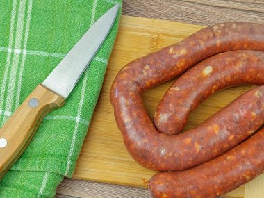 Merguez sosisi yakın plan, kesme tahtasında.