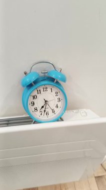 Isıtma radyatöründeki mekanik alarm saati.