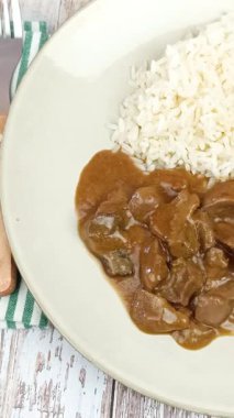 Soslu sığır böbreği ve tabakta pilav.
