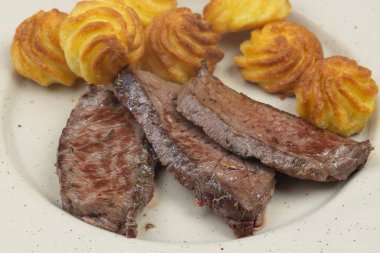 Kızarmış biftek ve patatesler, yakın plan.